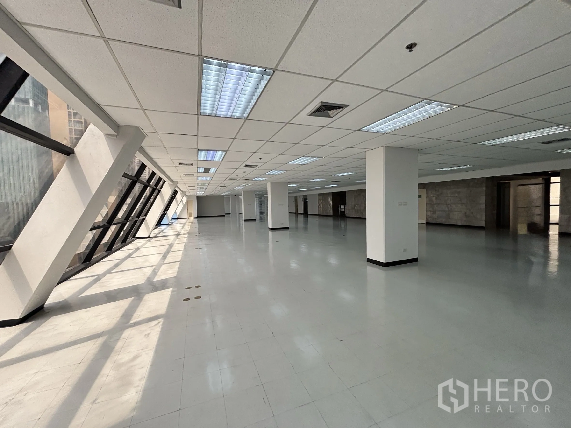 Office Space for rent in Ratchathewi, Bangkok - Bright perimeter with sunlit slanted windows leading into a deep open-plan office floor.