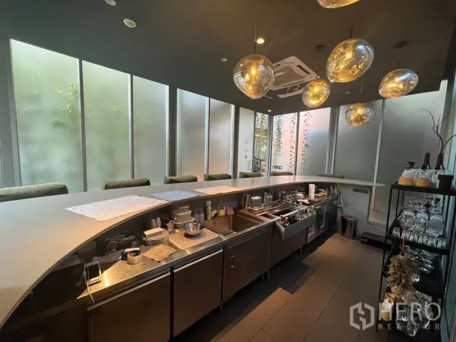 Retail Space for rent in Khlong Toei, Bangkok - Sleek retail interior with a curved bar counter, pendant lights, and floor‑to‑ceiling frosted windows.
