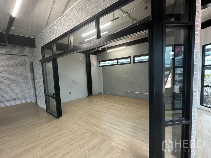 Office Space for rent in Chatuchak, Bangkok - Glass-partitioned meeting room with brick accent wall and exposed ceiling lighting.