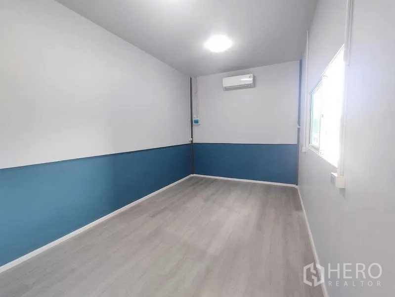 Warehouse for rent in Pak Kret, Nonthaburi - Air-conditioned office room with window and laminate flooring inside the warehouse.