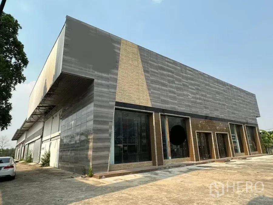 货栈 出租在Lam Luk Ka, Pathum Thani - 现代展厅与仓库外观，通高玻璃立面与车道，位于Lam Luk Ka。
