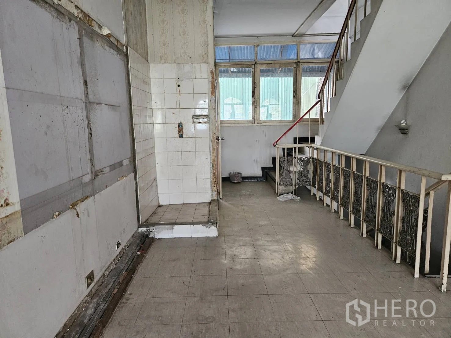 Shophouse for rent in Watthana, Bangkok - Landing level with staircase and a former pantry area clad in white tiles.