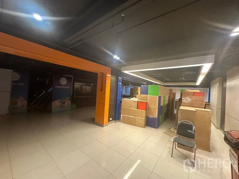 Office Space for rent in Khlong Toei, Bangkok - Lobby or storage zone with suspended rectangular light, tiled floor and stacked boxes.