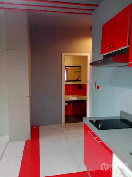 Office Space for rent in Khlong Toei, Bangkok - Compact pantry with red cabinetry, electric cooktop and a doorway to a private restroom.