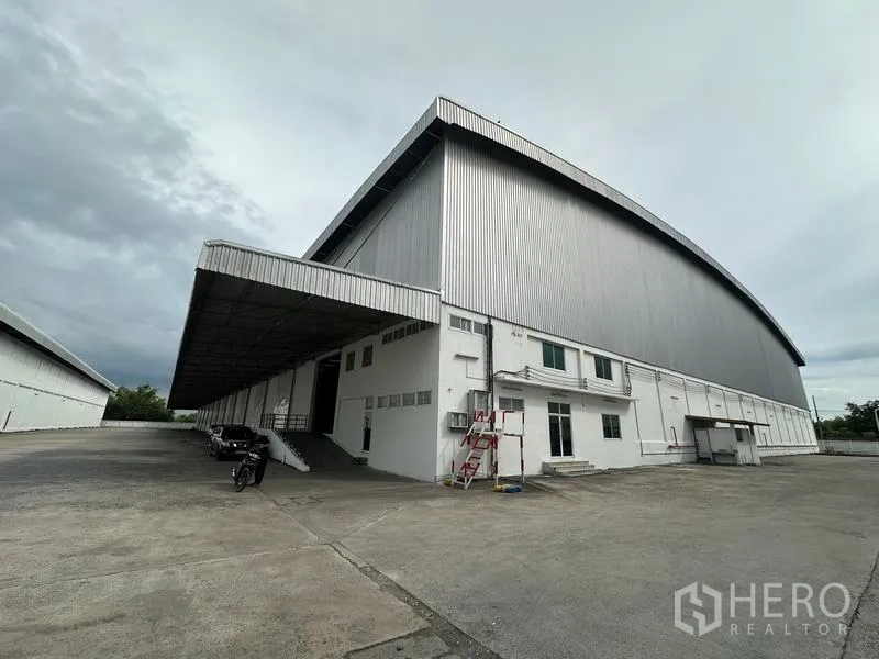 Warehouse for rent in Phra Nakhon Si Ayutthaya - Corner perspective of warehouse with deep canopy over loading area and attached office block.