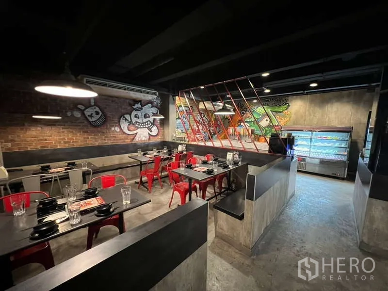 Shophouse for rent or sale in Khlong Toei, Bangkok - Elongated dining space with booth seating and red lattice window details.