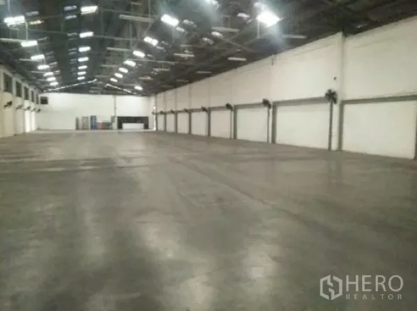 Warehouse for rent in Khlong Luang, Pathum Thani - Spacious warehouse interior with high steel roof, polished concrete floor and wall fans.