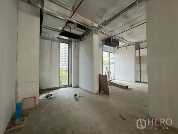 Retail Space for rent in Khlong Toei, Bangkok - Unfinished retail interior with ductwork, tall narrow glazing and concrete floor, ready for tenant fit-out near Phrom Phong BTS.