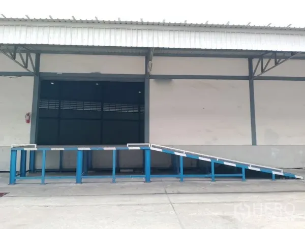 Warehouse for rent in Bang Phli, Samut Prakan - Covered loading bay with blue metal ramp at the warehouse entrance.
