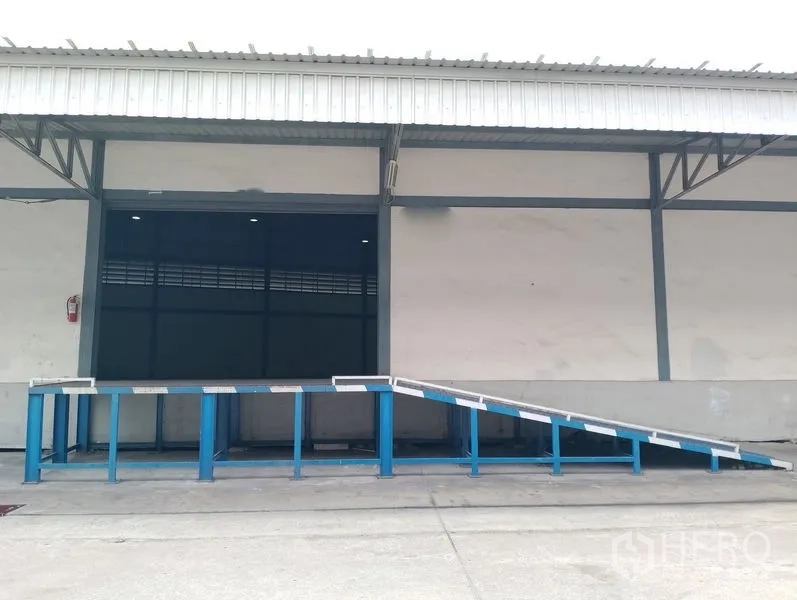 Warehouse for rent in Bang Phli, Samut Prakan - Covered loading bay with blue metal ramp at the warehouse entrance.