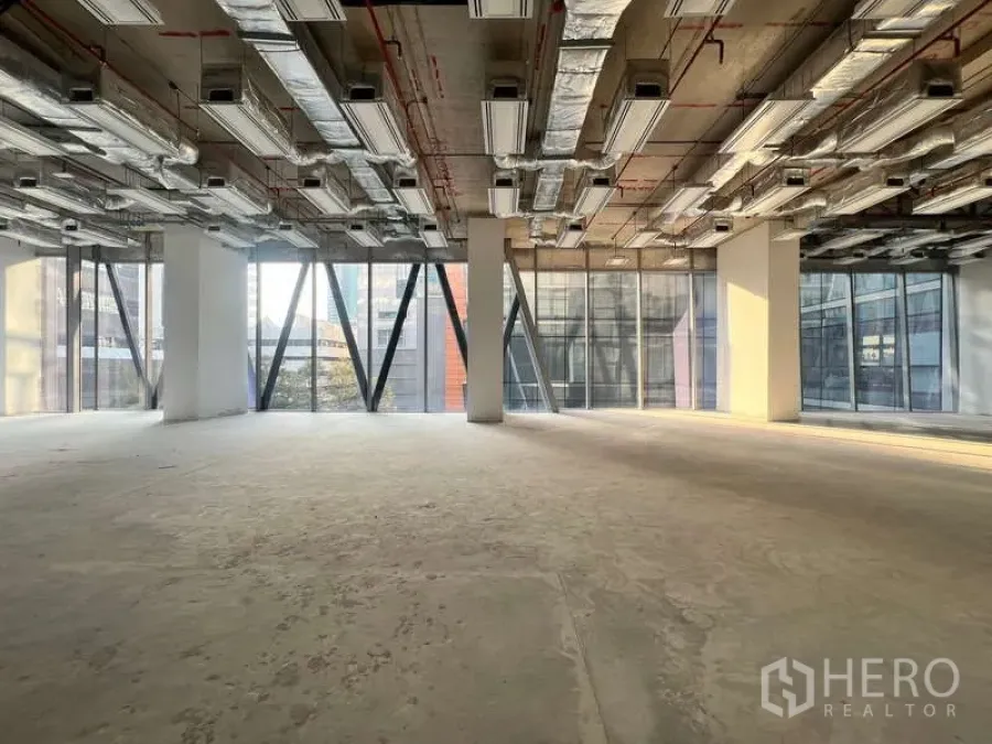 Office Space for rent - Expansive shell-and-core office with urban views through structural glass façades.