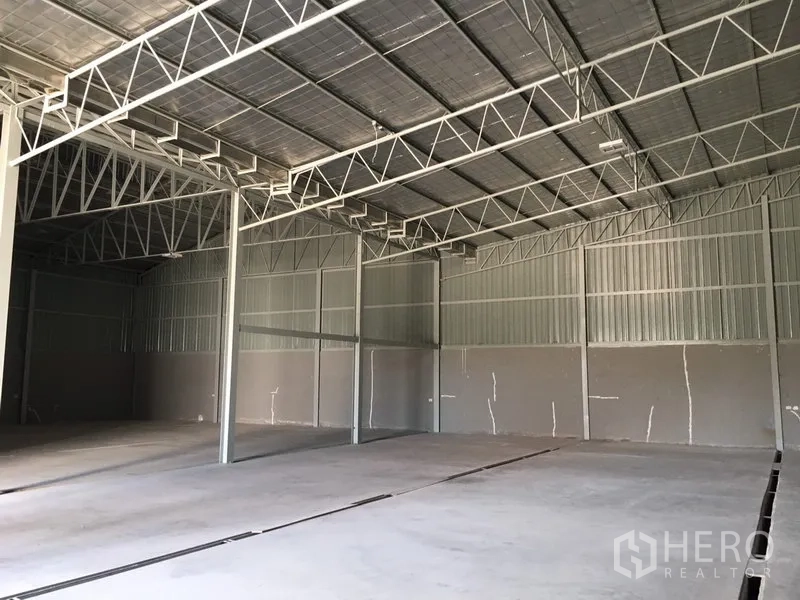 Warehouse for rent in Saphan Sung, Bangkok - Spacious warehouse interior with high truss roof, insulation and concrete floor.