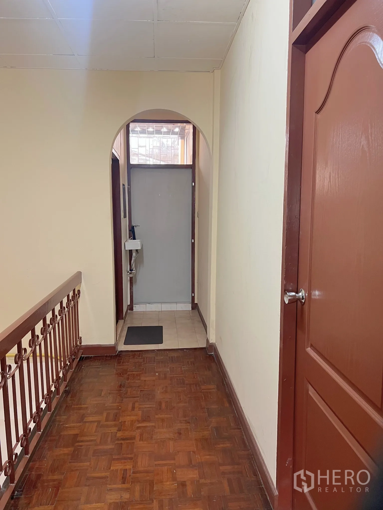 Townhouse for rent - Upstairs hallway with parquet floor, arched doorway and access to the bathroom.