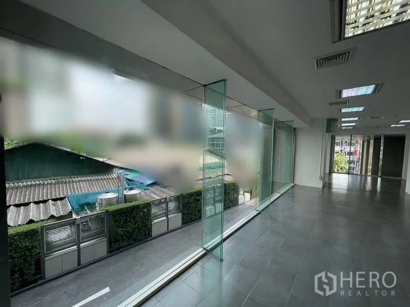 Office Space for rent - Glass curtain wall with city and rooftop views bringing daylight into the workspace.