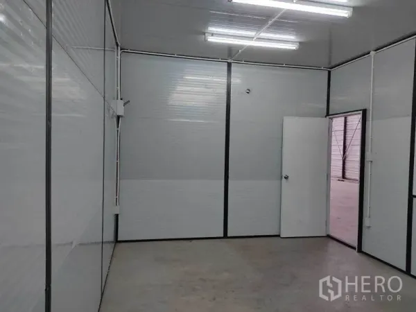 Warehouse for rent in Bang Phli, Samut Prakan - Bright partitioned office room inside the warehouse with fluorescent lighting and concrete floor.