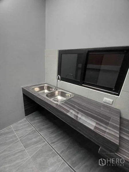 Retail Space for rent in Khlong Toei, Bangkok - Pantry with double stainless-steel sinks and stone countertop by a sliding window.