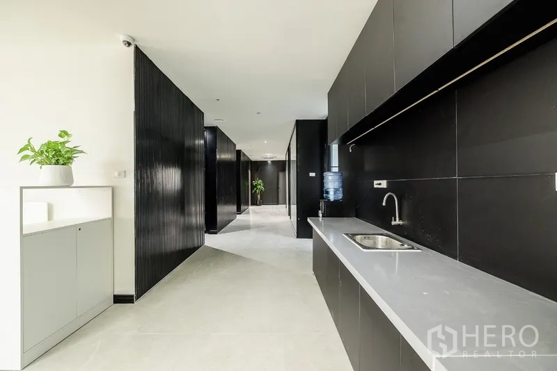 Office Space for rent or sale in Huai Khwang, Bangkok - Pantry zone with long counter, sink and water dispenser along the corridor.