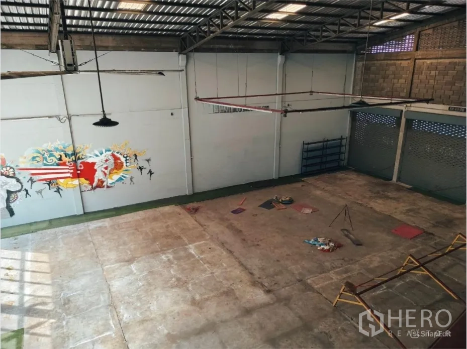 Warehouse for rent in Khlong Toei, Bangkok - High-angle interior showing loading shutters, open concrete floor and suspended lights.