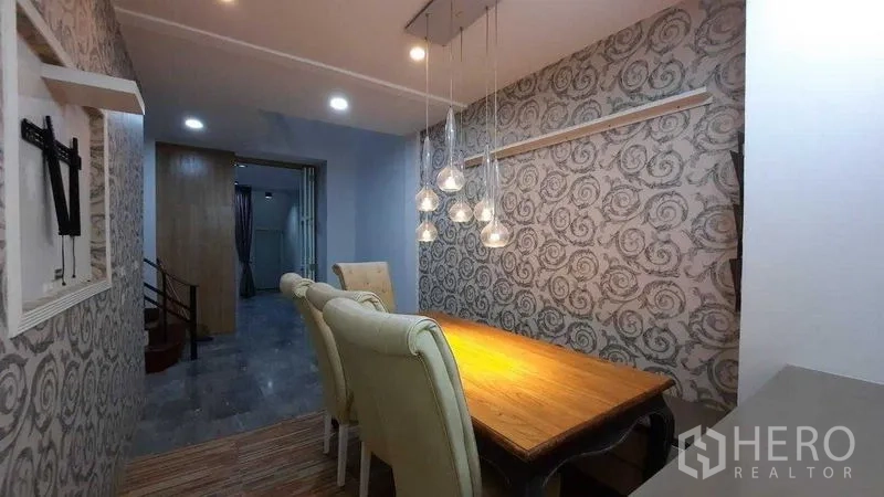 联排别墅 出租或出售在Suan Luang, Bangkok - 用餐角落，吊灯点缀与木质餐桌。