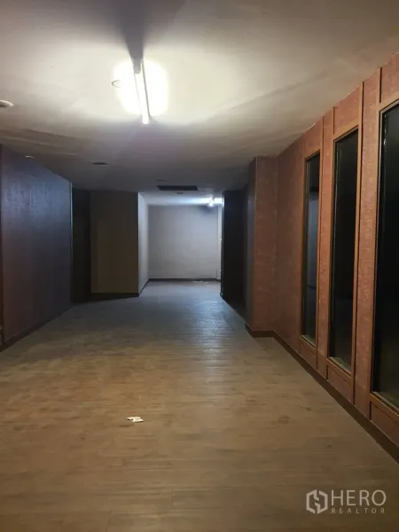 店屋 出租在Khlong Toei, Bangkok - 长走廊，木质地面、条形顶灯，一侧为高框内窗。