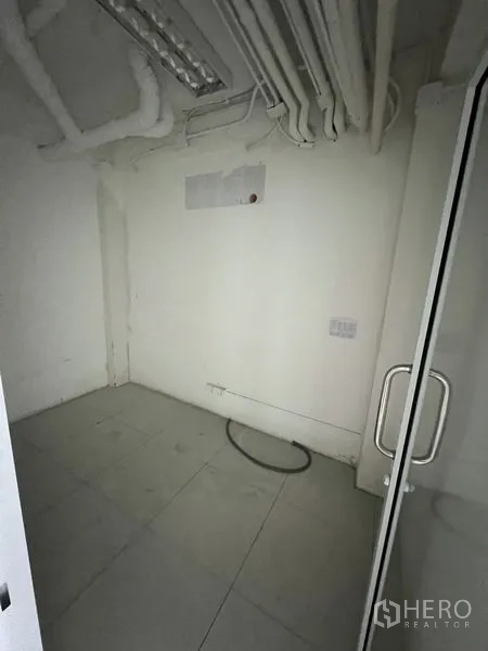 Retail Space for rent in Bang Rak, Bangkok - Compact utility or storage room with tiled floor and ceiling pipes.