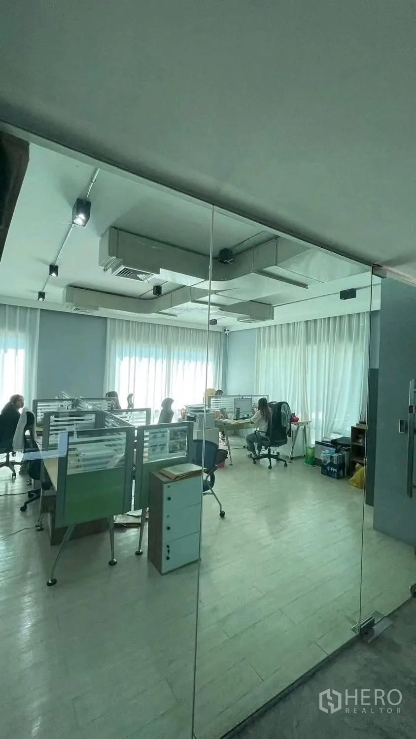 Home Office for rent or sale in Wang Thonglang, Bangkok - Office floor viewed through a glass wall with workstations and long curtains.