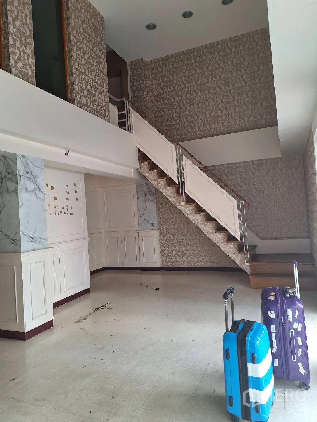 Retail Space for rent in Watthana, Bangkok - Double-height retail lobby with mezzanine staircase, paneled walls and marble accents.