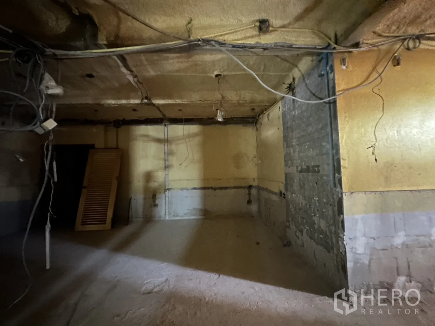 Retail Space for rent in Bang Rak, Bangkok - Unfinished corner area with exposed cabling and concrete floor.