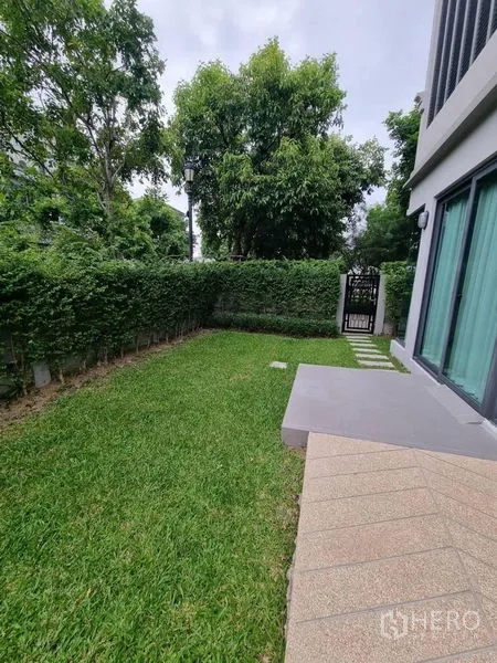 Detached House for rent - Private lawn garden bordered by hedges with a small patio and gate beside the home.