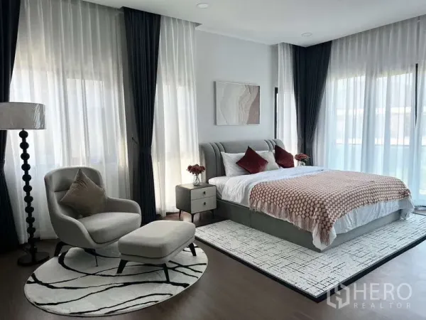Detached House for rent in Bang Phli, Samut Prakan - Bright master bedroom with large windows, sheer curtains, armchair and rug.