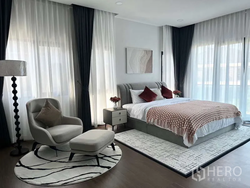 Detached House for rent in Bang Phli, Samut Prakan - Bright master bedroom with large windows, sheer curtains, armchair and rug.