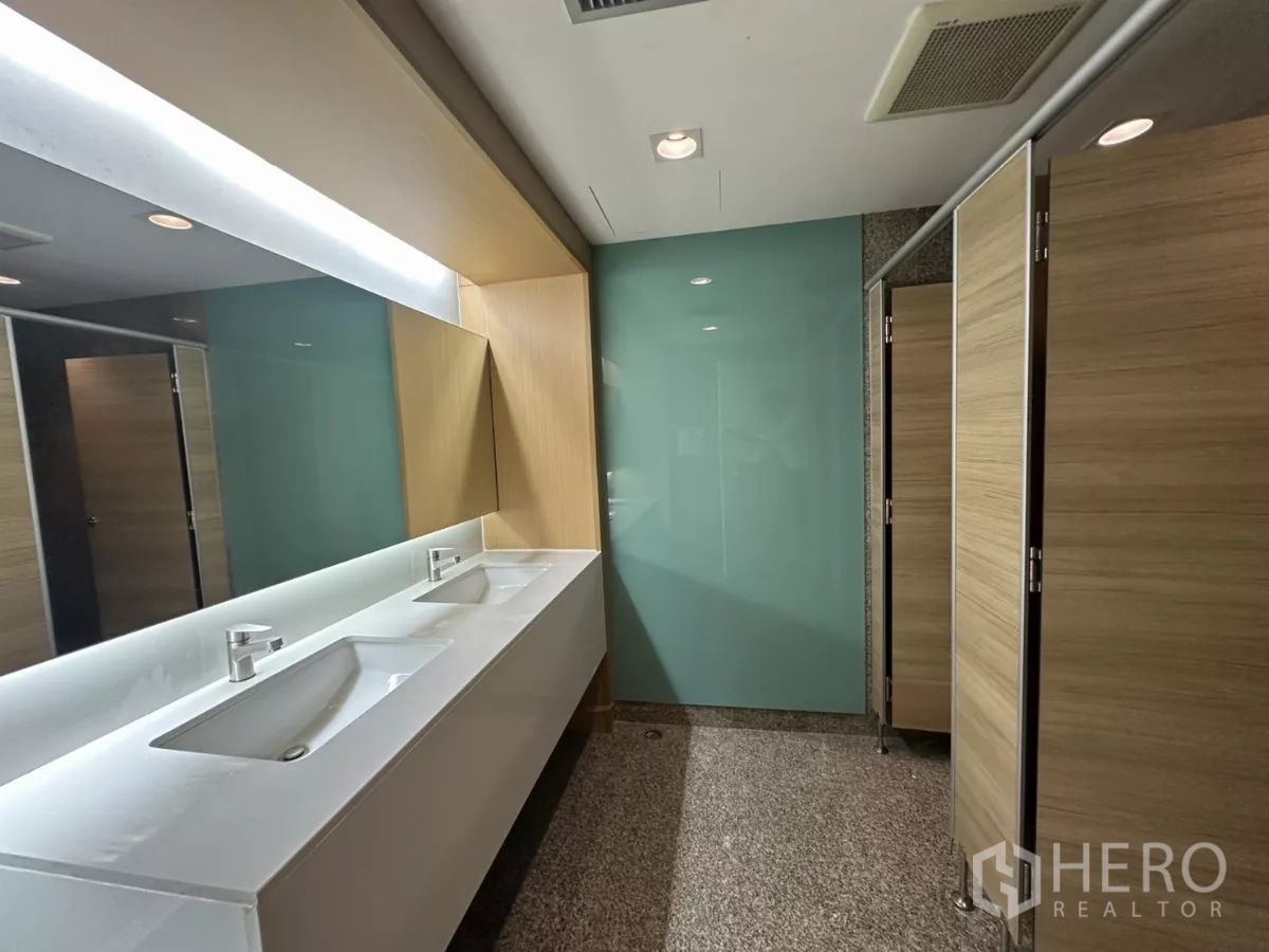 Office Space for rent in Watthana, Bangkok - Contemporary restroom with double sinks and wood-finished stalls.