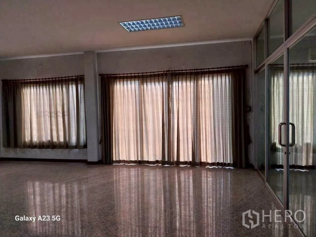 Factory for rent in Phra Samut Chedi, Samut Prakan - Bright office area with large curtained windows, polished floors, and glass partition doors.