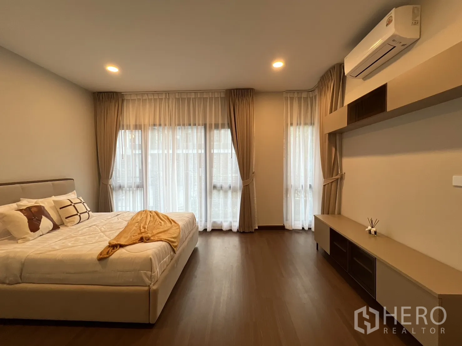 Detached House for rent or sale in Bang Phli, Samut Prakan - Bright bedroom with large windows, bed and wall-mounted console.