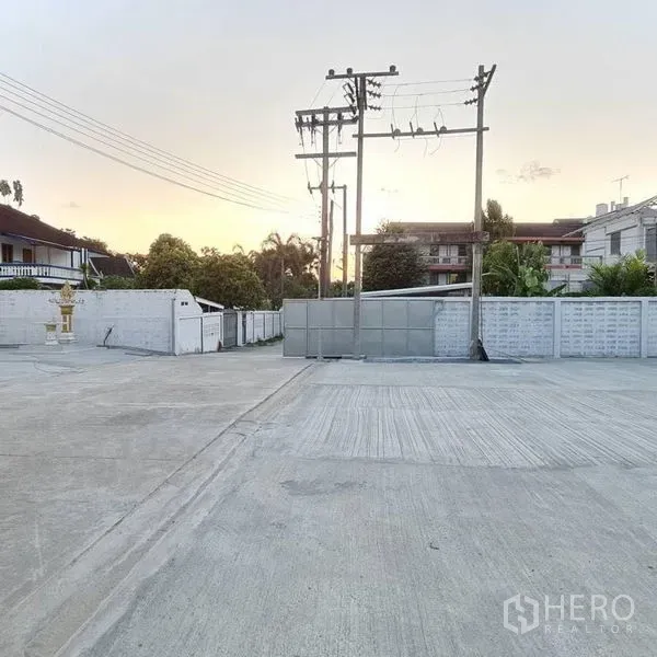 Warehouse for rent in Prawet, Bangkok - Wide gated entrance and expansive concrete yard in front of the property.