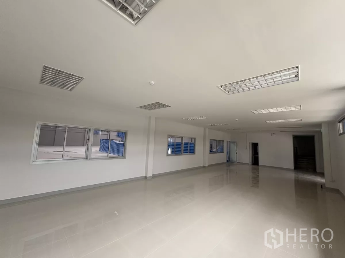 工厂 出租在Bang Phli, Samut Prakan - 明亮的夹层办公区，瓷砖地面、日光灯照明，窗户可俯瞰仓库。
