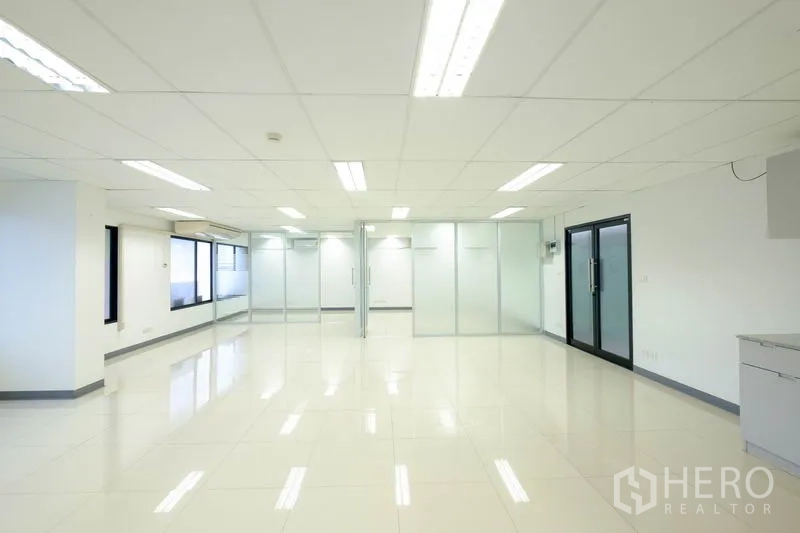Office Space for rent in Chatuchak, Bangkok - Light-filled office with glossy tiles, fluorescent ceiling lights and frosted glass walls.