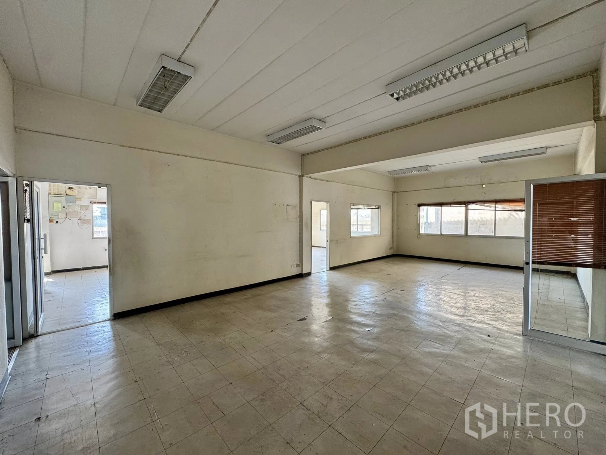 Warehouse for rent in Mueang Samut Sakhon, Samut Sakhon - Large open office with multiple windows and fluorescent lighting.