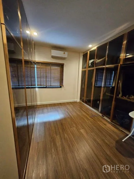 Detached House for sale in Mueang Pathum Thani, Pathum Thani - Walk-in closet room with floor-to-ceiling glass wardrobes and air conditioner.