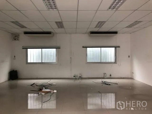地 出租在Phra Khanong, Bangkok - 空置办公室，瓷砖地面、吊顶灯具与壁挂式空调。