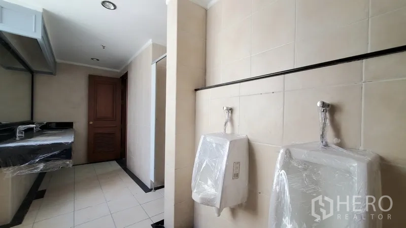 Office Space for rent in Watthana, Bangkok - Men’s bathroom with urinals, toilet stalls, and tiled finishes.
