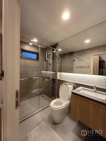Detached House for rent in Bang Kapi, Bangkok - Modern bathroom with glass shower enclosure and full-width mirror
