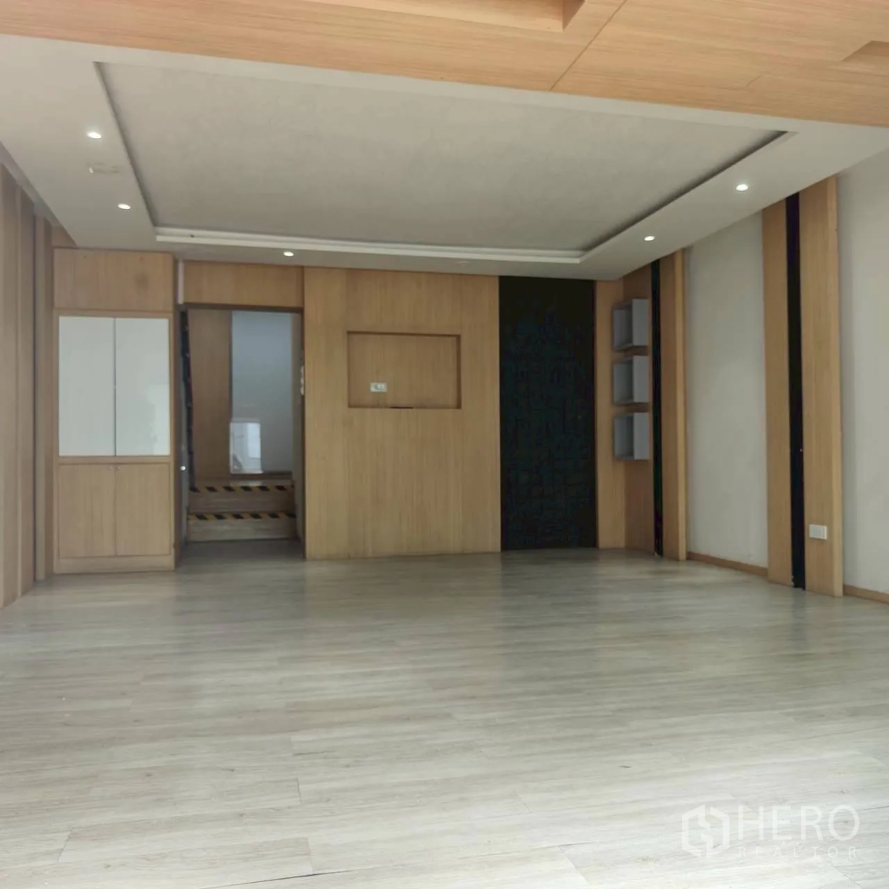 โฮมออฟฟิศ for rent in Watthana, Bangkok - ห้องโถงเปิดโล่งพื้นไม้ ผนังตกแต่ง และไฟดาวน์ไลท์