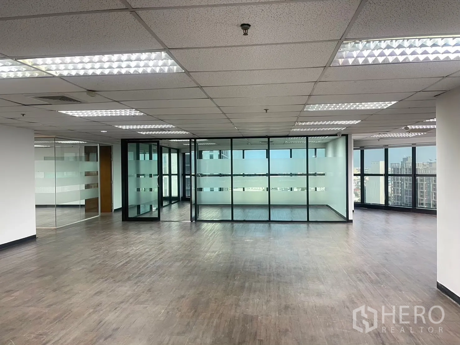 Office Space for rent in Watthana, Bangkok - Open-plan office with multiple glass offices and wide windows showing city views.