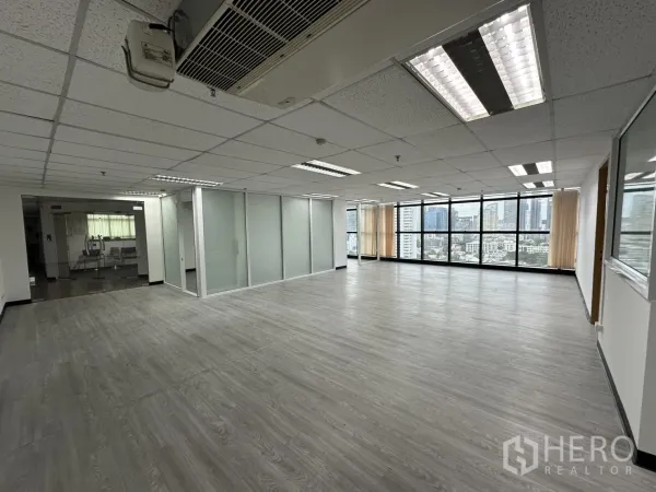 Office Space for rent in Watthana, Bangkok - Bright office interior with wood-look floors, ceiling lights, glass partitions and skyline views in Watthana.