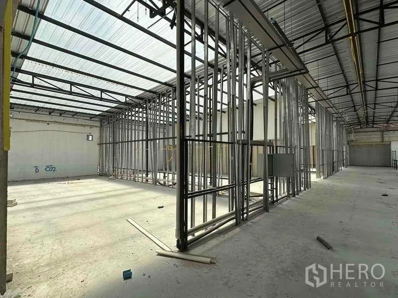 Warehouse for rent in Sai Noi, Nonthaburi - Corner bay of the warehouse showing steel framing, utilities and translucent roof panels.