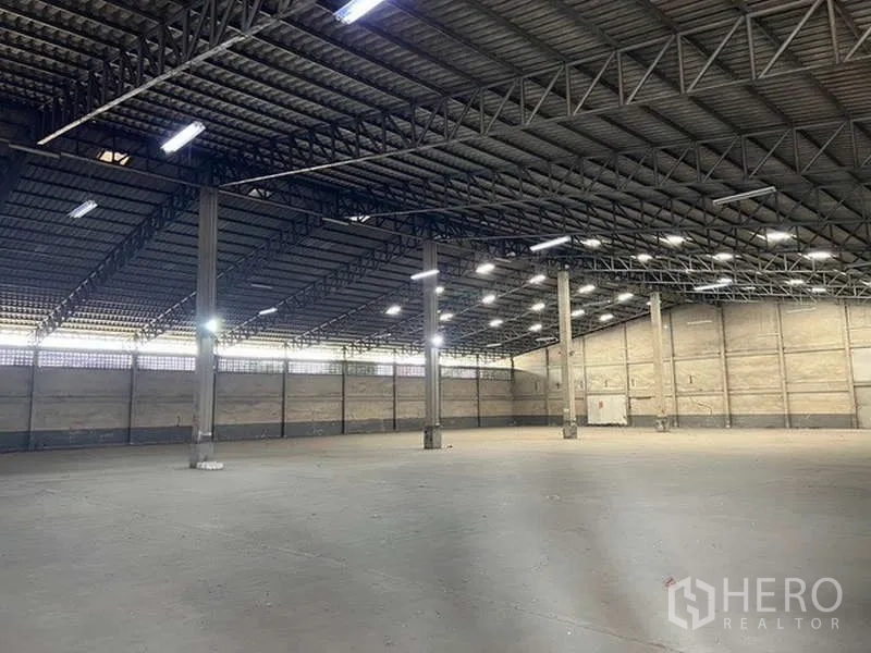Warehouse for rent - Bright industrial hall showing steel truss roof, LED lights and large clear floor.