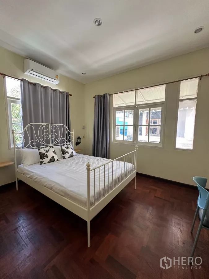 Home Office for rent in Suan Luang, Bangkok - Bedroom with white metal bedframe and three windows.