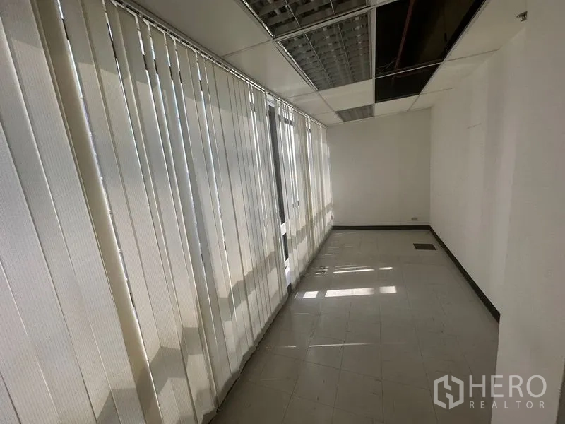 Office Space for rent in Khlong Toei, Bangkok - Bright corridor lined with vertical blinds and tiled floor beneath a suspended ceiling.