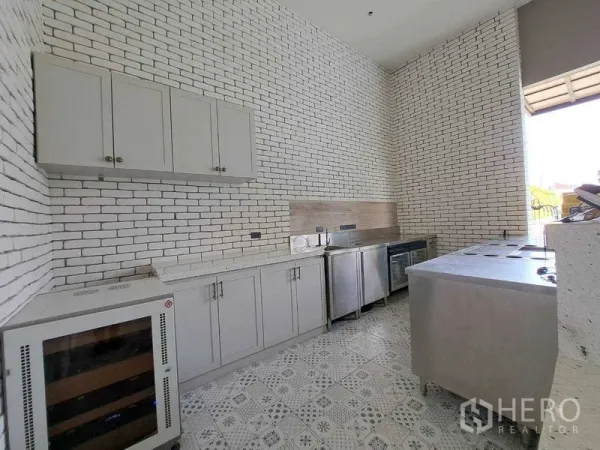 Retail Space for rent in Watthana, Bangkok - Built-in cabinets and undercounter fridges in a high-ceiling white brick kitchen.